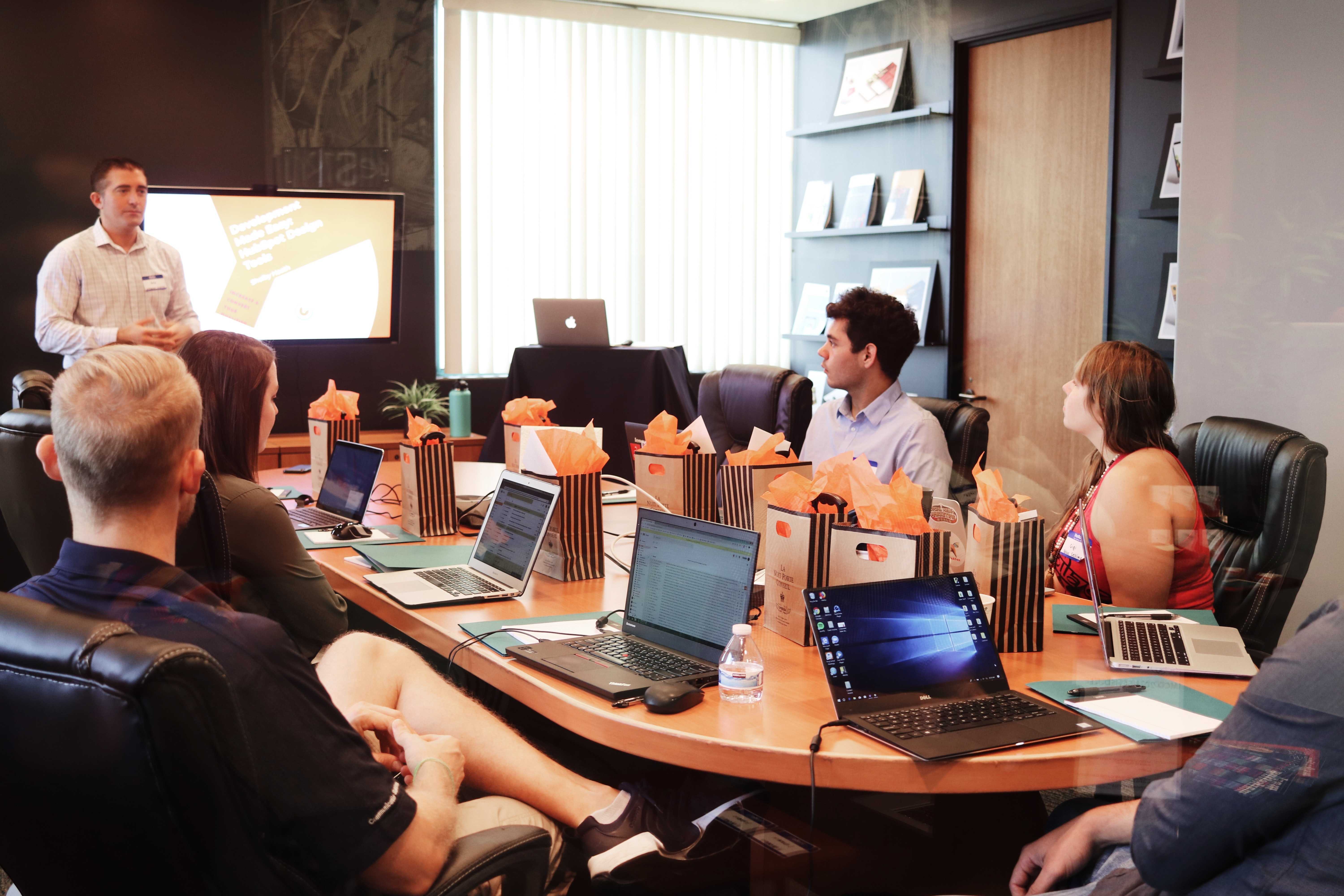 Marketing working around a desk with a presentor